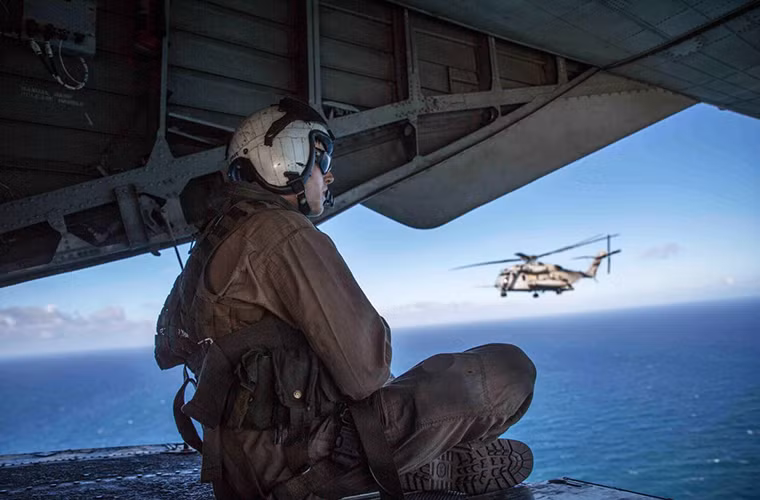 Giây phút thư giãn của một binh sĩ hậu cần thuộc lực lượng Lính thủy đánh bộ Mỹ trên trực thăng vận tải quân sự hạng nặng CH-53E khi đang bay trên vùng biển Hawaii vào tháng 7/2015.