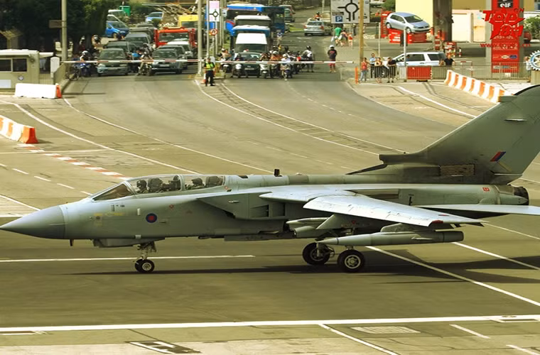 Căn cứ không quân Gibraltar của Không quân Hoàng gia Anh đóng tại vùng lãnh thổ hải ngoại Gibraltar tại Địa Trung Hải là một trong những căn cứ quân sự độc nhất vô nhị trên thế giới khi nó nằm gọn bên trong khu vực đông dân cư. Ảnh: Chiến đấu cơ Anh Tornado chạy trên đường băng cắt ngang đường dân sinh.