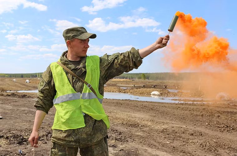 Một binh sĩ dùng pháo hiệu thông báo cho các đội thi kết thúc phần thi của mình.