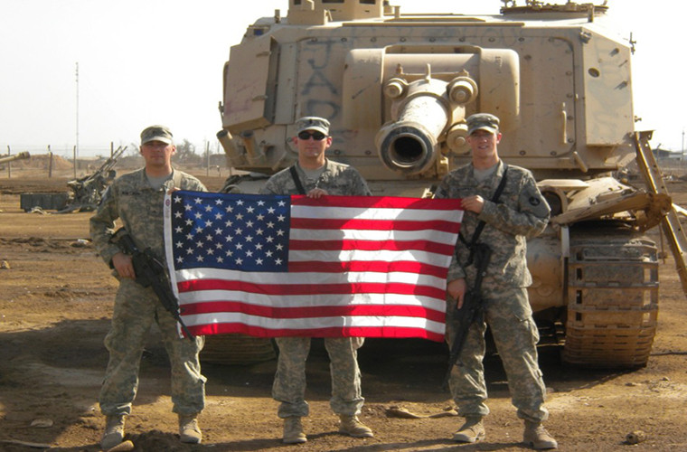 Từ năm 2003, quy mô của Taji ngày càng được mở rộng do tình trạng an ninh bất ổn tại Iraq sau khi Mỹ lật đổ chính quyền Saddam Hussein. Các thiết bị quân sự bị hư hỏng hoặc phá hủy trong giao tranh đều được chuyển đến Taji. Trong ảnh là một nhóm binh sĩ Mỹ chụp ảnh trước một khẩu pháo tự hành GCT 155mm bị bỏ lại Taji.