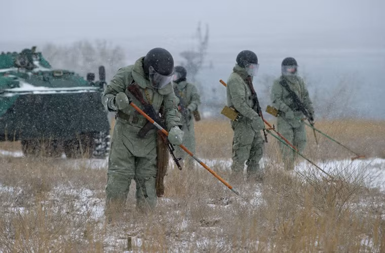 Ở một địa điểm khác gần đó, binh sĩ Nga lại huấn luyện diễn tập rà phá bom mìn tại khu vực phòng thủ với sự hổ trợ của các phương tiện cơ giới.