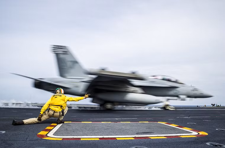 Trung úy Chris Denton, sĩ quan bộ phận máy phóng trên tàu USS George Washington ra hiệu cho một chiếc F/A-18E cất cánh. Nguồn ảnh: Business Insider
