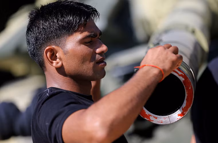 Một binh sĩ Ấn Độ kiểm tra nòng pháo của chiếc T-72B3 trước giờ Tank Biathlon khai mạc.