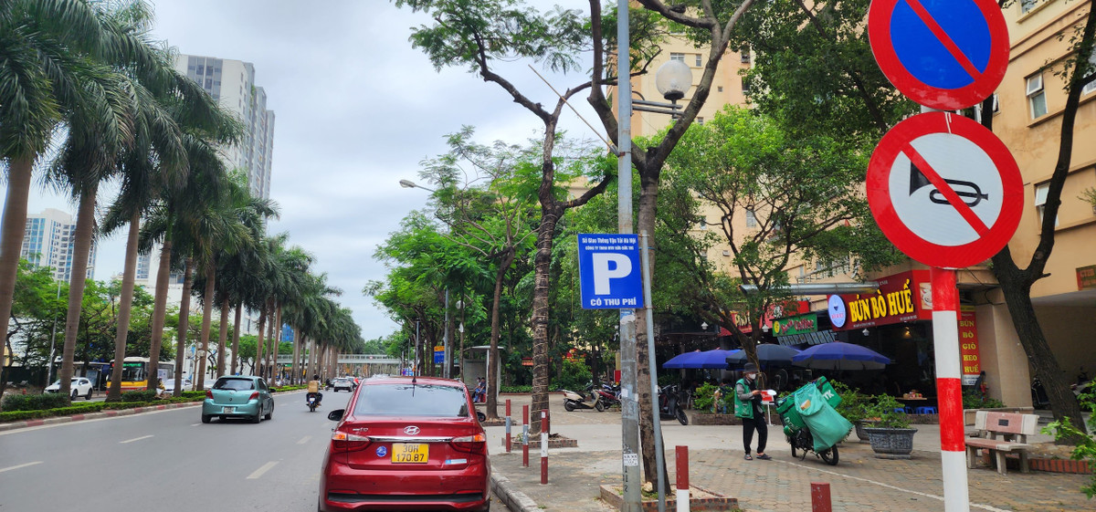 Theo Luật Giao thông đường bộ - biển cấm đỗ dừng xe có hiệu lực cấm các loại xe cơ giới dừng và đỗ lại ở phía đường có đặt biển, trừ các xe được ưu tiên. Tuy nhiên, nhiều tuyến đường Hà Nội như: Lê Đức Thọ, Nguyễn Hoàng...vẫn xảy ra nghịch lý: Cho phép sử dụng lòng đường để trông giữ xe ngay sau biển cấm dừng đỗ. Ảnh chụp trên đường Lê Đức Thọ, quận Nam Từ Liêm.