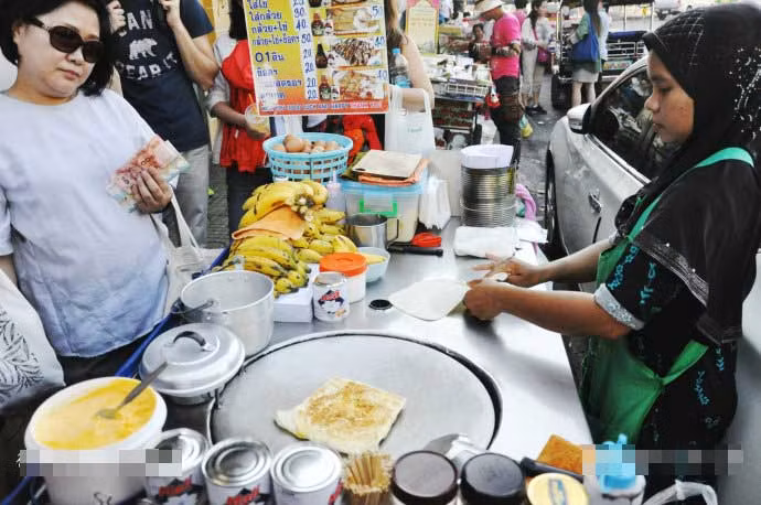 Du khách chăm chú nhìn cô chủ hàng người theo Hồi giáo đang thoăn thoắt làm bánh. Ảnh Sina