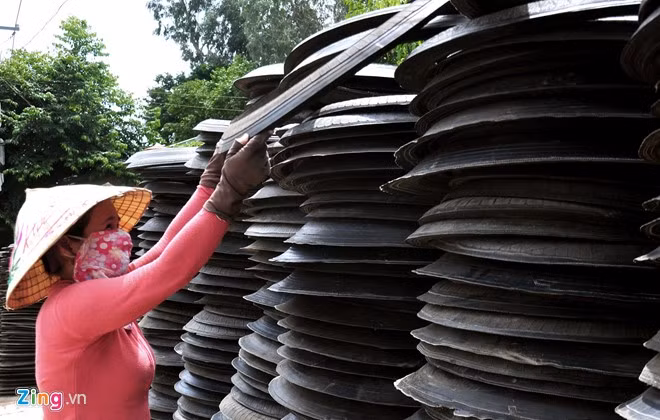 Người dân mang sản phẩm cao su sau khi được tái chế từ lốp ôtô cũ chất cao ven đường chờ xe tải đến chở hàng đưa đi tiêu thụ khắp nơi trong cả nước.