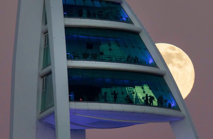 Trăng tròn đầu tiên của năm 2022 hé rạng sau tháp Spinnaker ở Portsmouth, Anh.