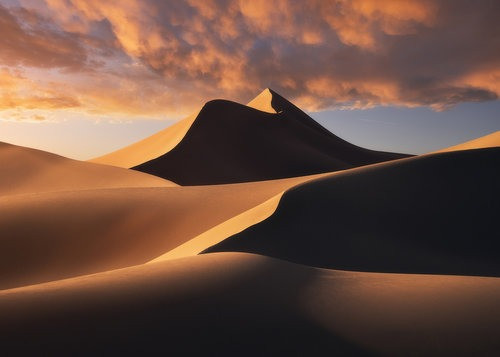 Cấu trúc xung quanh cũng góp phần tạo ra và phóng đại âm thanh, với đồi núi tạo ra luồng khí tập trung gió vào các vùng xung quanh đụn cát. Khi gió thổi qua, cát rung động và tạo ra âm thanh. Lỗ khí giữa các hạt cát có thể tăng cường âm thanh như một buồng cộng hưởng.