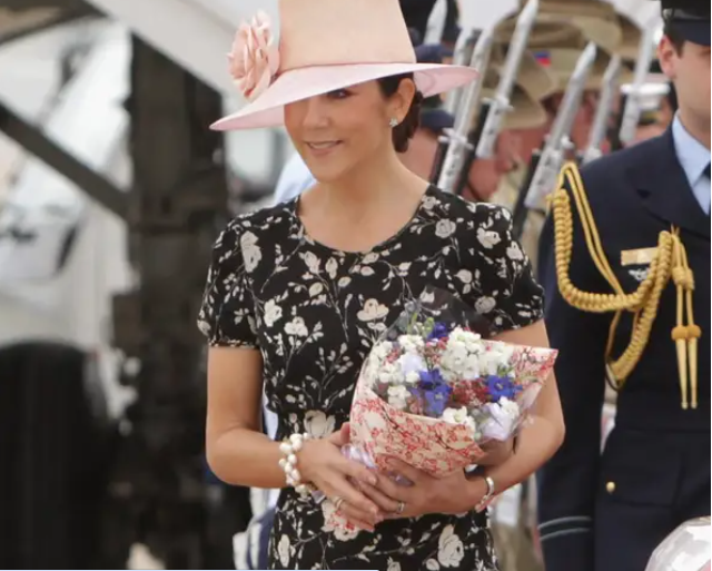 Trong chuyến thăm Australia năm 2011, Công nương Mary mặc một chiếc váy hoa dài đến đầu gối và đội chiếc mũ màu hồng đính một bông hoa.