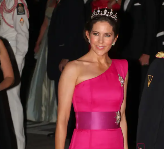 Công nương Mary nổi bật khi diện chiếc váy lệch vai màu hồng sáng của David Anderson và đội vương miện tại bữa tiệc trang trọng chào mừng Hoàng tử Albert và Công nương Charlene của Monaco năm 2011.