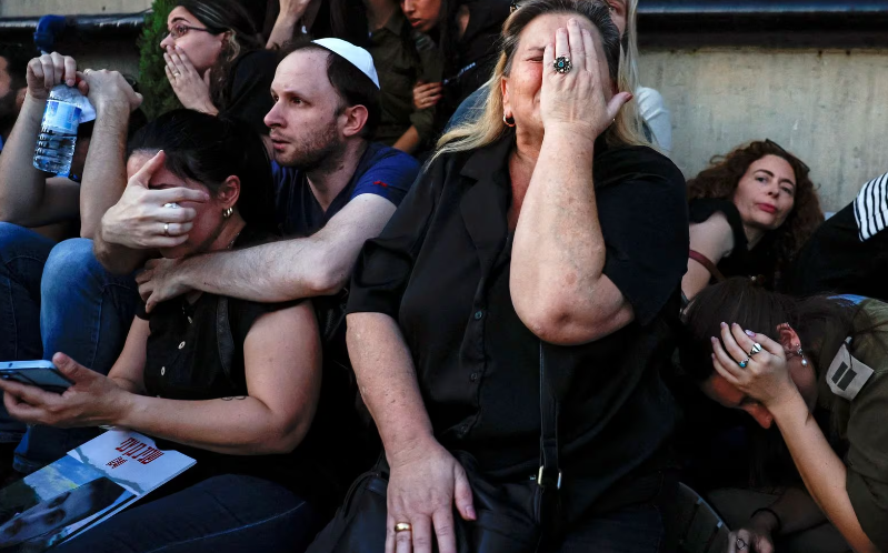 Tiếng còi báo động tên lửa vang lên giữa lúc mọi người đang tham dự đám tang của Sagiv Ben Zvi, 24 tuổi, ở Holon, Israel, ngày 26/10.