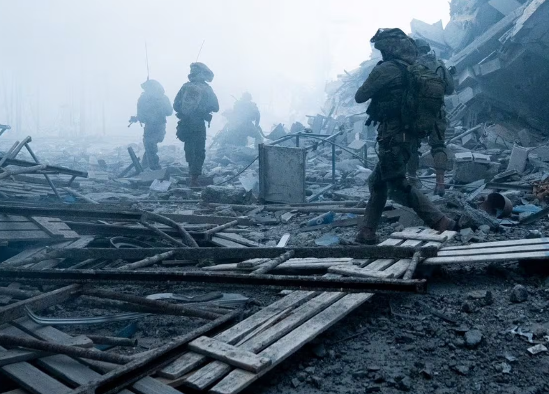 Lực lượng Israel đi qua một tòa nhà đổ nát ở Gaza hôm 21/12/2023.