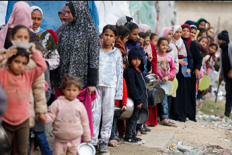 Người dân Palestine xếp hàng chờ nhận đồ ăn do một bếp từ thiện nấu ở Rafah, phía nam Dải Gaza, ngày 16/1.