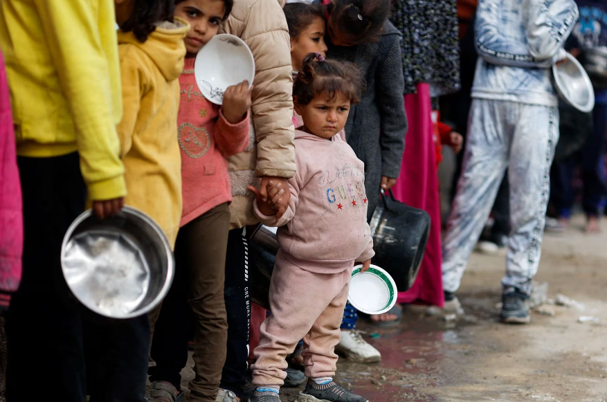 Các em nhỏ mang theo bát xếp hàng chờ nhận đồ ăn.