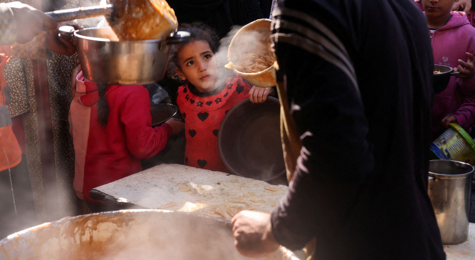 Hãng Reuters mới đây đăng tải loạt ảnh ghi lại cảnh người dân và các em nhỏ Palestine xếp hàng để nhận đồ ăn do một bếp từ thiện nấu trong bối cảnh thiếu nguồn cung ứng thực phẩm ở Rafal, phía nam Dải Gaza.
