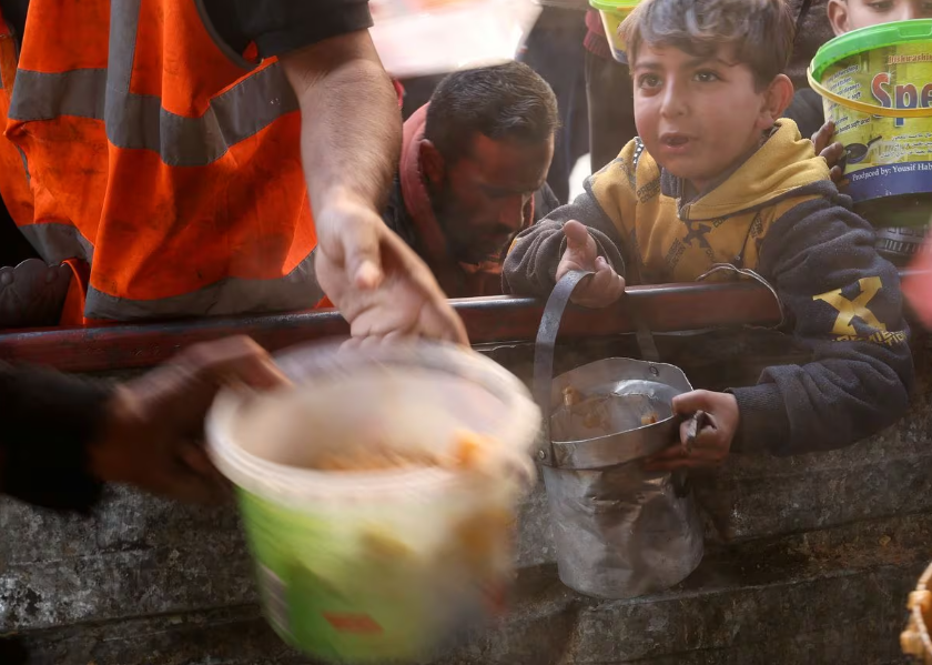 Người dân Palestine xếp hàng chờ nhận đồ ăn từ thiện ở Rafah hôm 16/1.