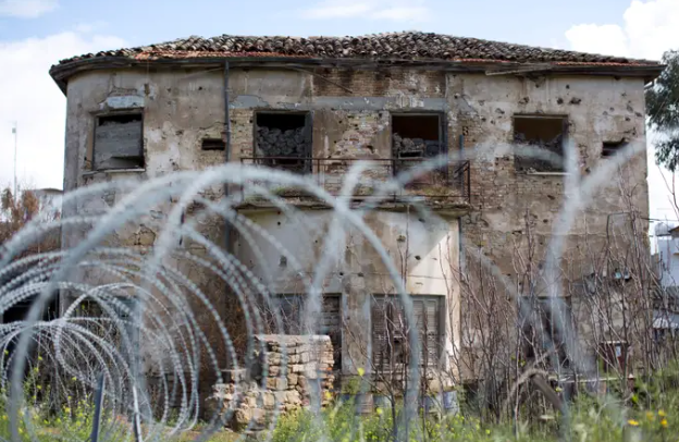 Những ngôi nhà cũ bỏ hoang được bao quanh bởi hàng rào thép gai.