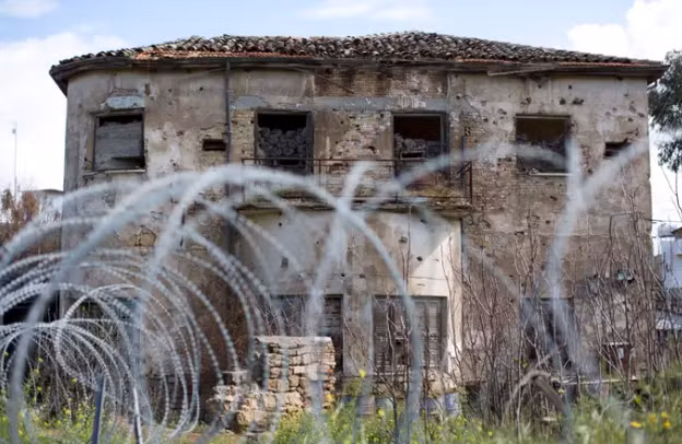 Những ngôi nhà cũ bỏ hoang được bao quanh bởi hàng rào thép gai.