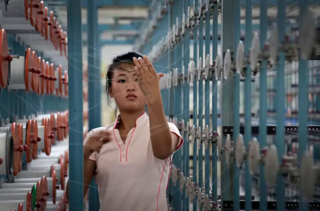 Trong ảnh là một nữ công nhân làm việc tại nhà máy dệt Kim Jong Suk Bình Nhưỡng ngày 31/7/2014. Nhà máy dệt lụa Kim Jong Suk đã thông báo tuyển dụng 1.600 công nhân, chủ yếu là phụ nữ.