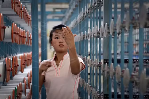 Trong ảnh là một nữ công nhân làm việc tại nhà máy dệt Kim Jong Suk Bình Nhưỡng ngày 31/7/2014. Nhà máy dệt lụa Kim Jong Suk đã thông báo tuyển dụng 1.600 công nhân, chủ yếu là phụ nữ.