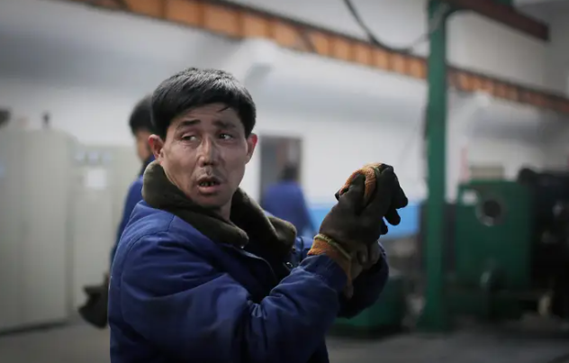 Một công nhân tháo găng tay tại Nhà máy Dây điện Bình Nhưỡng 326 ở Bình Nhưỡng, Triều Tiên, vào ngày 10/1/2017. Nhà máy dây điện 326 ở Bình Nhưỡng cho biết họ có 1.000 công nhân mỗi ngày.