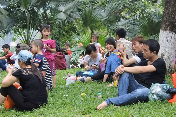 Nắng nóng, những bãi cỏ được tận dụng làm nơi nghỉ trưa của nhiều người.