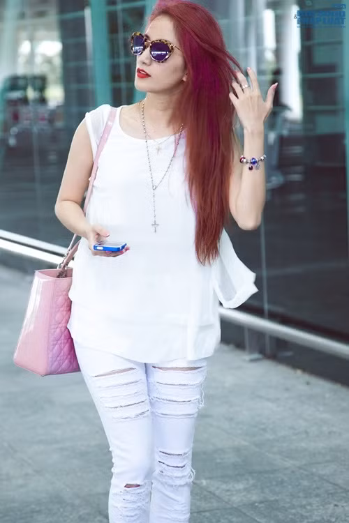 Chiếc túi xách Dior màu hồng nhạt trở thành điểm nhấn cho bộ trang phục Khánh Thi diện trên người. Ảnh: Tom Nguyễn.