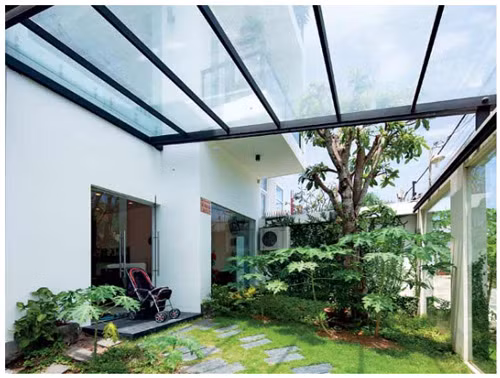 Sân vườn được thiết kế mở, phần mái bằng kính giúp lấy ánh sáng chan hòa cho không gian.