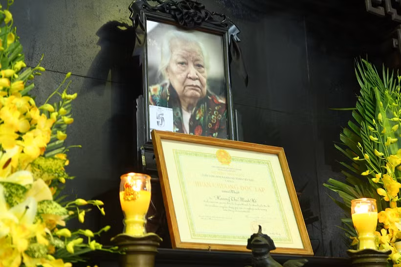 Cụ bà Hoàng Thị Minh Hồ là con của cụ Hoàng Đạo Phương, vừa là nhà nho vừa là một thương gia giàu có ở phố Hàng Đào. Năm 18 tuổi bà Minh Hồ lập gia thất với nhà tư sản Trịnh Văn Bô, người hiến tặng đất nước 5.147 lượng vàng trong Tuần lễ vàng (năm 1945). lễ truy điệu từ 15h đến 15h30 ngày 13/11. Lễ an táng diễn ra cùng ngày tại nghĩa trang Thiên đức Vĩnh Hằng Viên (ở xã Trung Giáp, huyện Phù Ninh, tỉnh Phú Thọ).