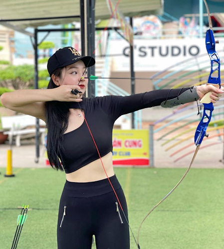 Mới đây, hot girl Lê Vũ Quỳnh Trâm đăng tải hình ảnh diện áo croptop chéo vai phối cùng quần legging đi bắn cung, gây chú ý trên MXH.