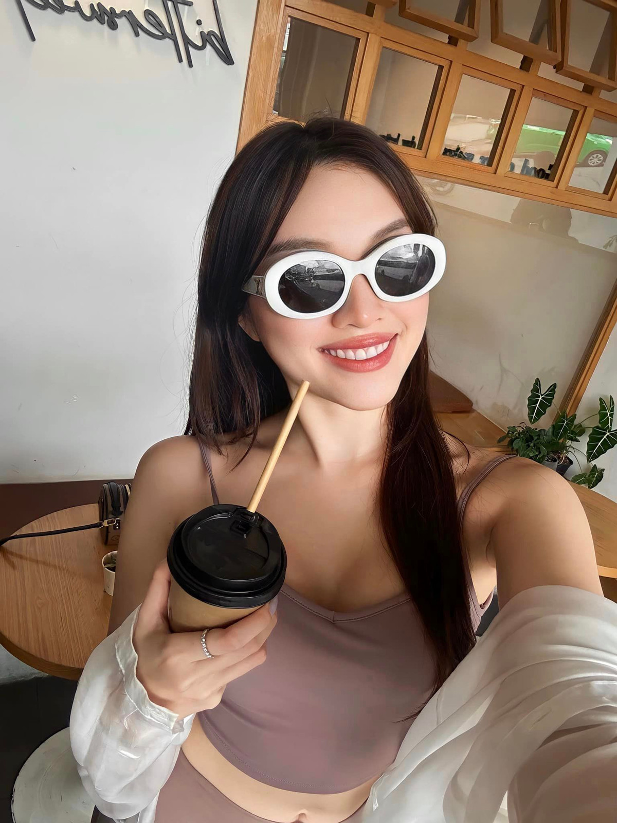 Trong hình "MC 3000 chữ" mặc bra cùng quần legging và phối thêm một chiếc áo khoác mỏng màu trắng bên ngoài.