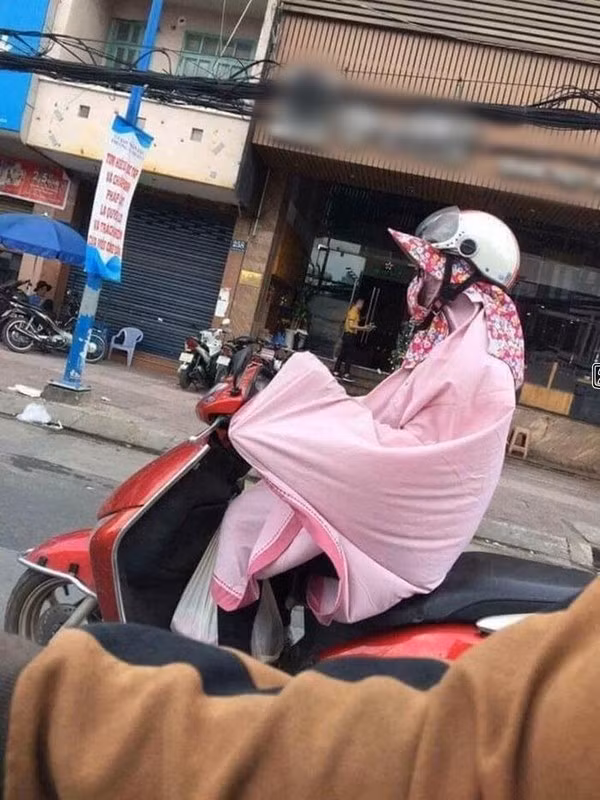 Các chị em sợ nắng và đen da nên không ngần ngại dùng chăn quấn khắp người để tránh nắng.