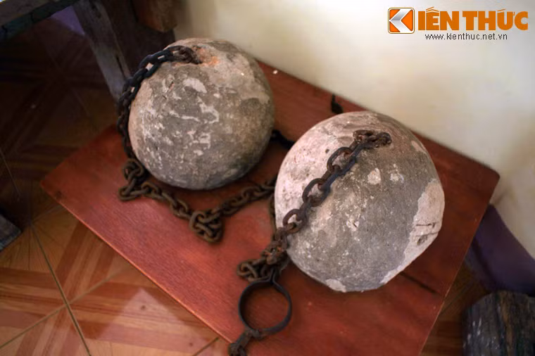 Nhiều hiện vật lịch sử của khu nhà ngục khét tiếng vẫn được lưu giữ và trưng bày trong nhà tưởng niệm của khu di tích. Ảnh: Những quả tạ dùng để xích chân tù khổ sai khi lao động ngoài trời.
