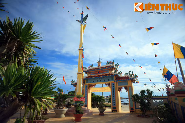 Sau tam quan là cột phướn nằm giữa khoảng sân rộng lát gạch kẻ hoa văn, trang trí cờ phướn màu sắc rực rỡ.