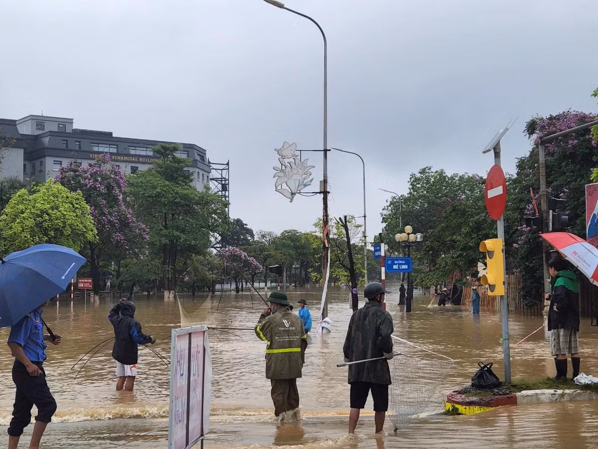 Người dân mang vó, cần câu ra phố bắt cá. (Ảnh: Dân Việt)