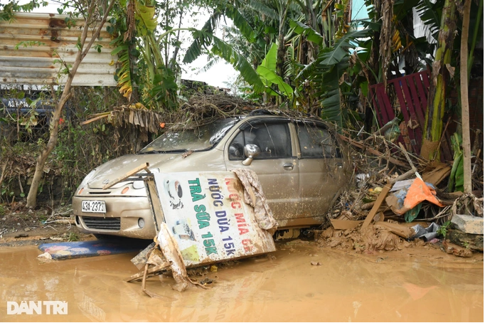 Chiếc ô tô chênh vênh bên miệng cống thoát nước. Đêm qua, tại đường Mẹ Suốt, có một bé gái 16 tuổi bị dòng nước cuốn trôi và tử vong (Ảnh: Quốc Triều).