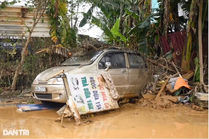 Chiếc ô tô chênh vênh bên miệng cống thoát nước. Đêm qua, tại đường Mẹ Suốt, có một bé gái 16 tuổi bị dòng nước cuốn trôi và tử vong (Ảnh: Quốc Triều).