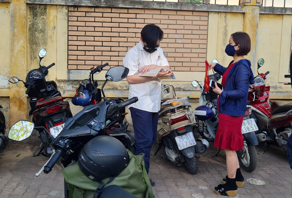 Tại điểm Trường THCS Nam Trung Yên, một thí sinh đến sớm, chưa vào trường ngay mà còn nấn ná bên ngoài, tranh thủ ôn bài đến những phút cuối cùng trước giờ thi.