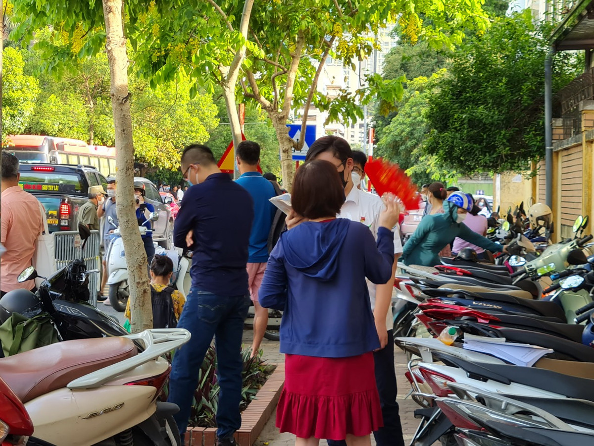 Mẹ của học sinh này đứng bên, không ngừng quạt cho con. Nhiều phụ huynh chia sẻ, đã lo lắng đến mất ăn mất ngủ trước kỳ thi vào lớp 10 này của con. Nhưng bố mẹ vẫn cố tỏ ra bình thản để con được thoải mái, bớt áp lực.