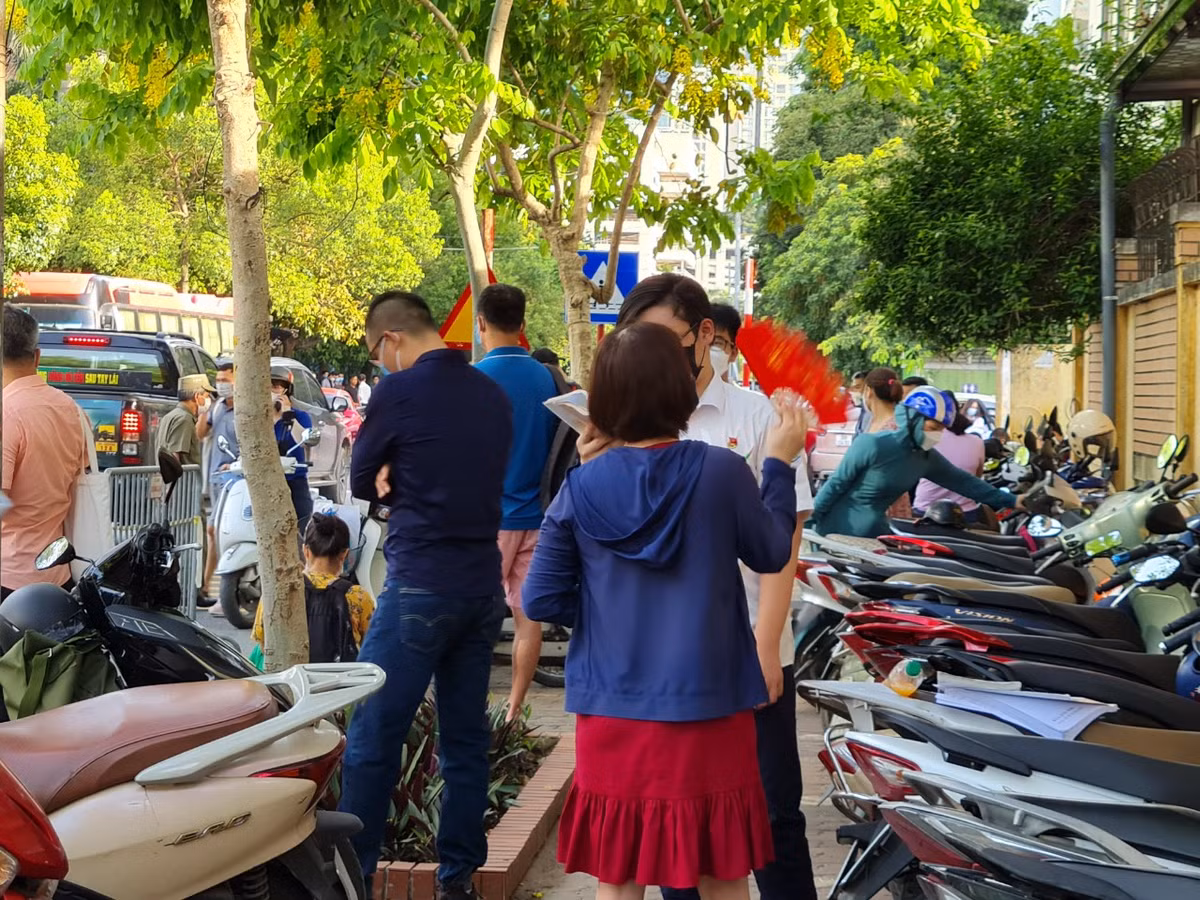 Mẹ của học sinh này đứng bên, không ngừng quạt cho con. Nhiều phụ huynh chia sẻ, đã lo lắng đến mất ăn mất ngủ trước kỳ thi vào lớp 10 này của con. Nhưng bố mẹ vẫn cố tỏ ra bình thản để con được thoải mái, bớt áp lực.