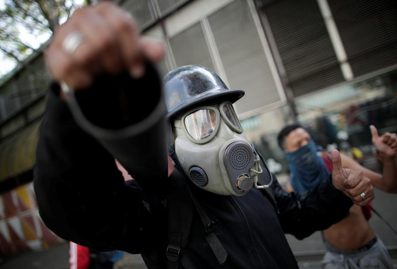 Người ủng hộ phe đối lập đeo mặt nạ phòng độc trong cuộc đụng độ với lực lượng an ninh Venezuela tại Caracas.