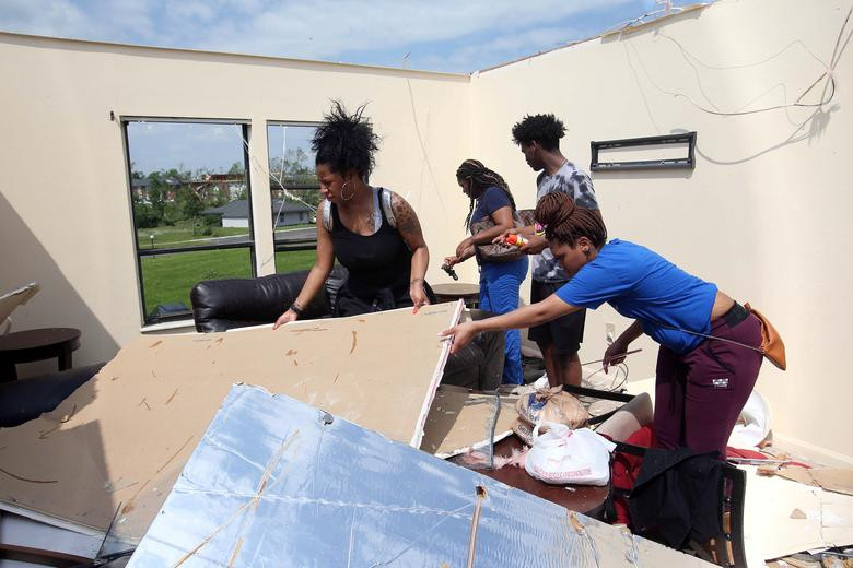 Stavion Byrd cùng bạn bè dọn dẹp đống đổ nát ngổn ngang trong căn hộ của cô ở thành phố Trotwood, gần Dayton, ngày 28/5. Ảnh: Reuters.