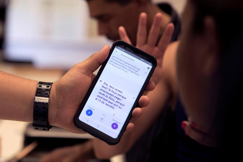 Một tình nguyện viên sử dụng điện thoại để dịch từ tiếng Anh sang tiếng Bồ Đào Nha trong lúc trò chuyện với một di dân đến từ Brazil tại cơ sở ở Deming.