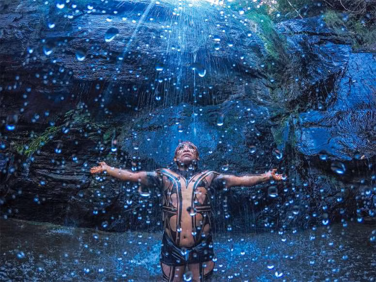 Bức ảnh ấn tượng của một thổ dân Yawalapiti dưới thác nước ở Vườn Quốc gia Chapada dos Veadeiros tại Goiás.