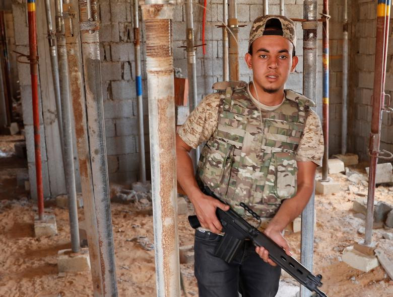 Thành viên GNA kiểm tra một ngôi nhà gần căn cứ của lực lượng trung thành với Tướng Khalifa ở ngoại ô Tripoli ngày 15/5.