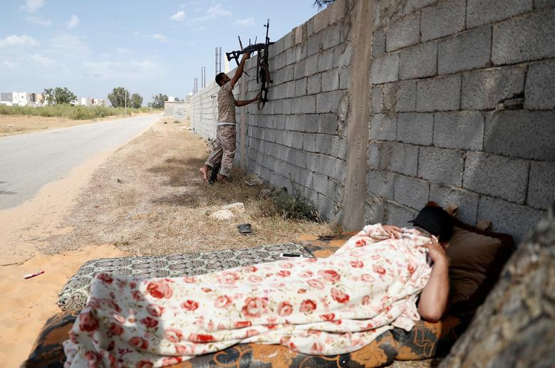Một thành viên của lực lượng trung thành với Thủ tướng Fayez Al-Sarraj tranh thủ nằm nghỉ trên chiến tuyến ở ngoại ô Tripoli ngày 12/5.