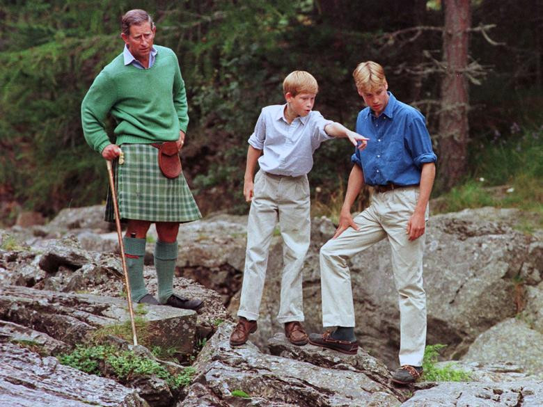 Hoàng tử William và Harry đứng cạnh cha, Thái tử Charles, trên bờ sông Muick gần Ballater trong kỳ nghỉ hè tại Lâu đài Balmoral, tháng 8/1997.