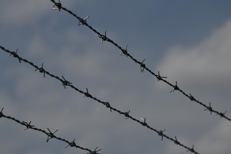 Hàng rào thép gai bao quanh khu "trại tị nạn" cho người nhập cư này.