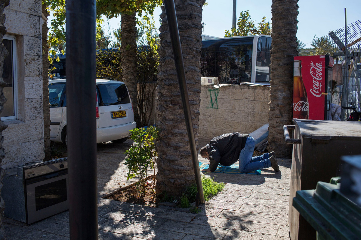 Jamil Rajbi cầu nguyện tại bãi đổ xe gần Cổng Damascus. Ảnh: NYT.