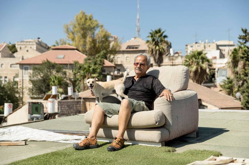 Ông Koko Deri ngồi trên sân thượng của nhà mình ở khu phố Musrara, Jerusalem. Ảnh: The Guardian.